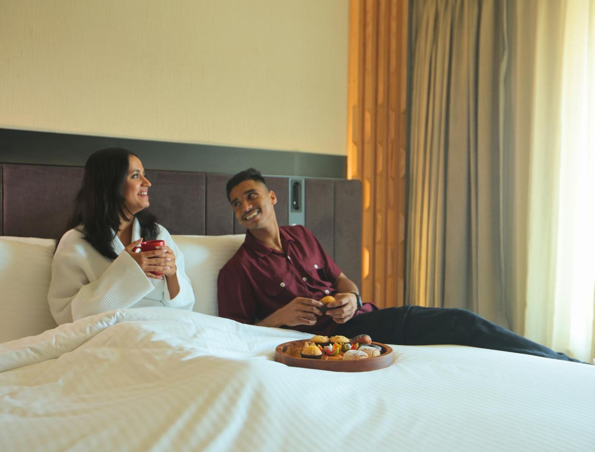 Novotel Hyderabad Airport Экстерьер фото A couple enjoying room service at a hotel